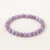 Kunzite Energy Bracelet with smooth lavender-purple crystal beads laid on off-white linen background.